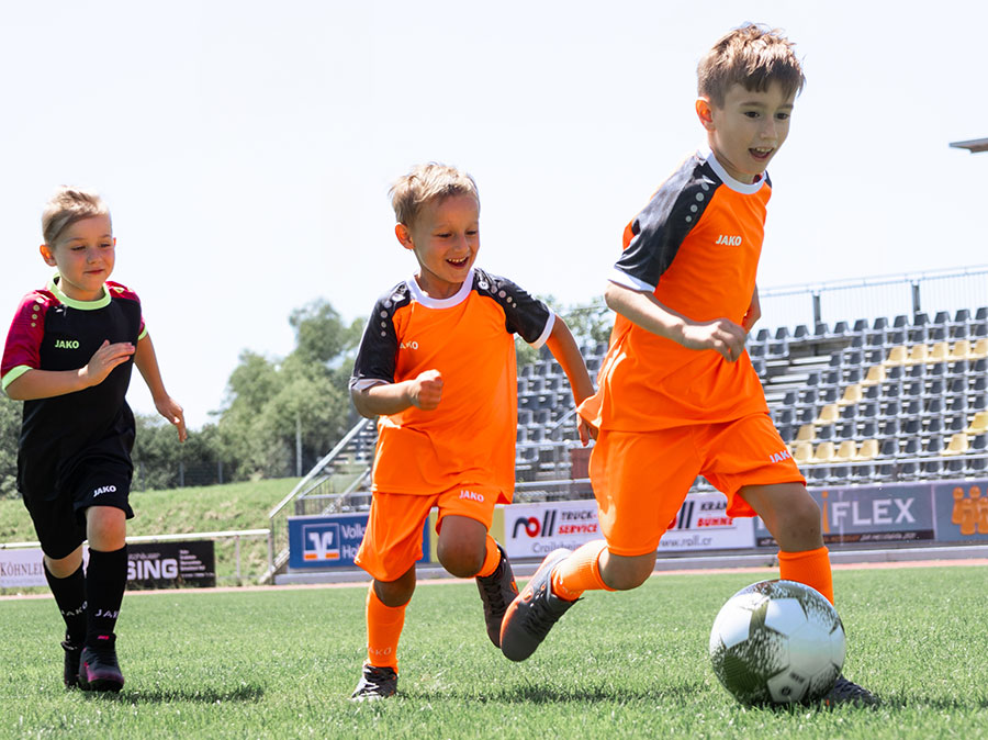 Enfants jouant au football avec des maillots JAKO