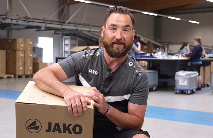 Mitarbeiterin aus der Logistik bei JAKO mit einem Stapel Pakete