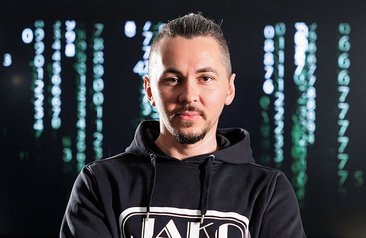 Mitarbeiter von JAKO im Bereich E-Commerce / Digital vor einem Fernseher, der Matrix-Code zeigt