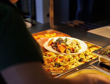 JAKO Mitarbeiterin bedient sich in der Kantine am kostenfreien Mittagessen