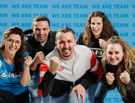 Mitarbeiter von JAKO vor der WE ARE TEAM Wand