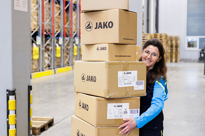 Mitarbeiterin von JAKO mit Kartons im Lager